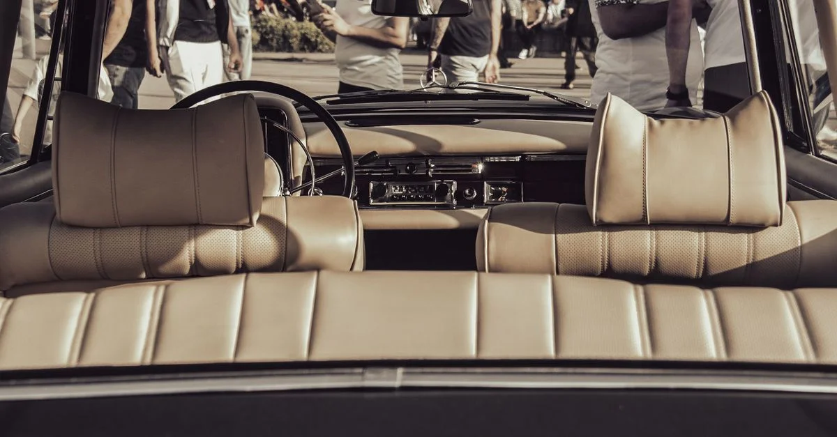 Un intérieur de voiture vintage classique avec des sièges en cuir et un tableau de bord, parfait pour les passionnés d'automobile.