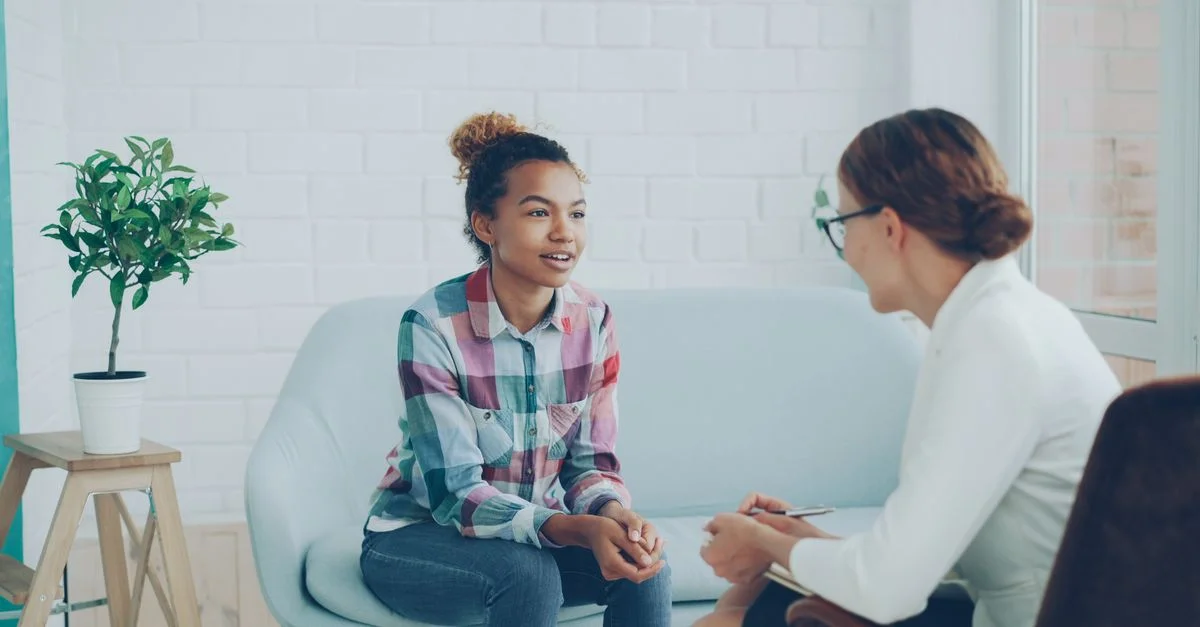 Adolescent et thérapeute dans un environnement de counseling calme.